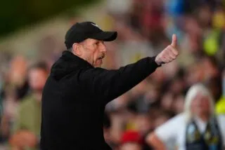 Un joueur de QPR se chauffe avec le coach d'Oxford United