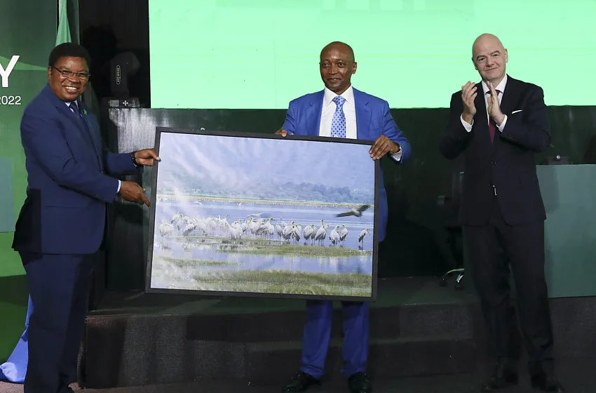 Le Premier ministre de l’époque Kassim Majaliwa, le président de la CAF Patrice Motsepe et celui de la FIFA Gianni Infantino, en train de s’arracher un tableau pour leur bureau, en 2022.