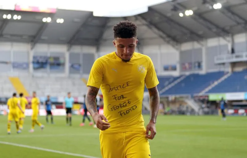 Les joueurs du Borussia et du Hertha posent un genou à terre avant leur match