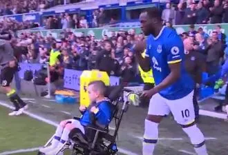 Lukaku entre sur le terrain avec un jeune handicapé