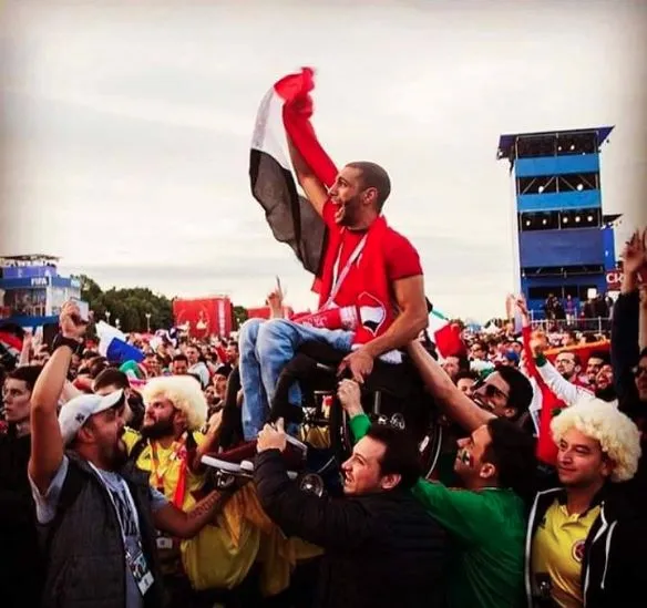 Photo : un fan égyptien en fauteuil porté dans une fan zone
