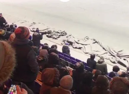 Un joueur de Peterborough aide à déneiger pour poursuivre le match